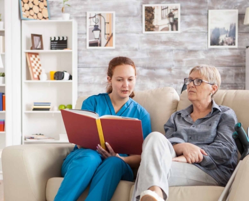 caregiver reading a book to a patient