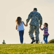Soldier walking with little girls holding hands