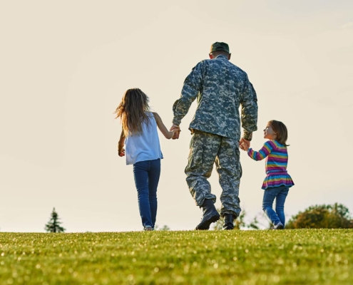 Soldier walking with little girls holding hands