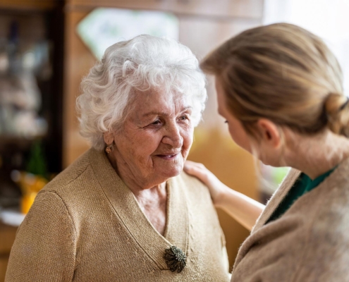 Side view of a caretaker and a senior patient conversing